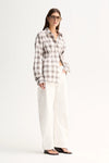 A model wears the White Check button-up shirt with white trousers in a three-quarter front view.