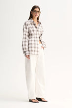 A model wears the White Check button-up shirt with white trousers in a three-quarter front view.