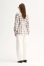 A model wears the White Check shirt in a full-length back view showing its long sleeves and shaped silhouette.