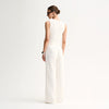 A model wears the Elka Collective Lindsay Knit Top in white with matching wide-leg trousers in a back studio view.
