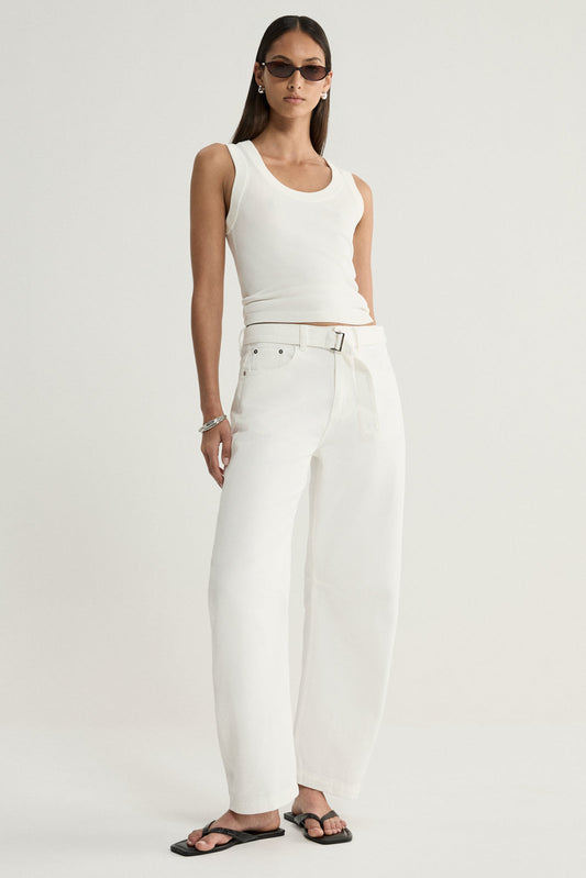 A model wearing ivory wide-leg denim pants with a removable tie belt, styled with a white sleeveless top, dark sunglasses and black flat sandals in a full-length front view.