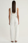 A rear view of a model wearing ivory wide-leg denim pants, showing the back pockets, waistband and long straight legs, paired with a white sleeveless top.
