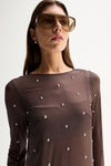 Close-up view showing the slate sheer fabric, crew neckline, long sleeve and scattered hot fix stud details.