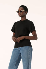 Model wearing the black Zoe Tee with light blue jeans and sunglasses, showing the relaxed boxy silhouette, short sleeves and crew neckline, upper-body angled view
