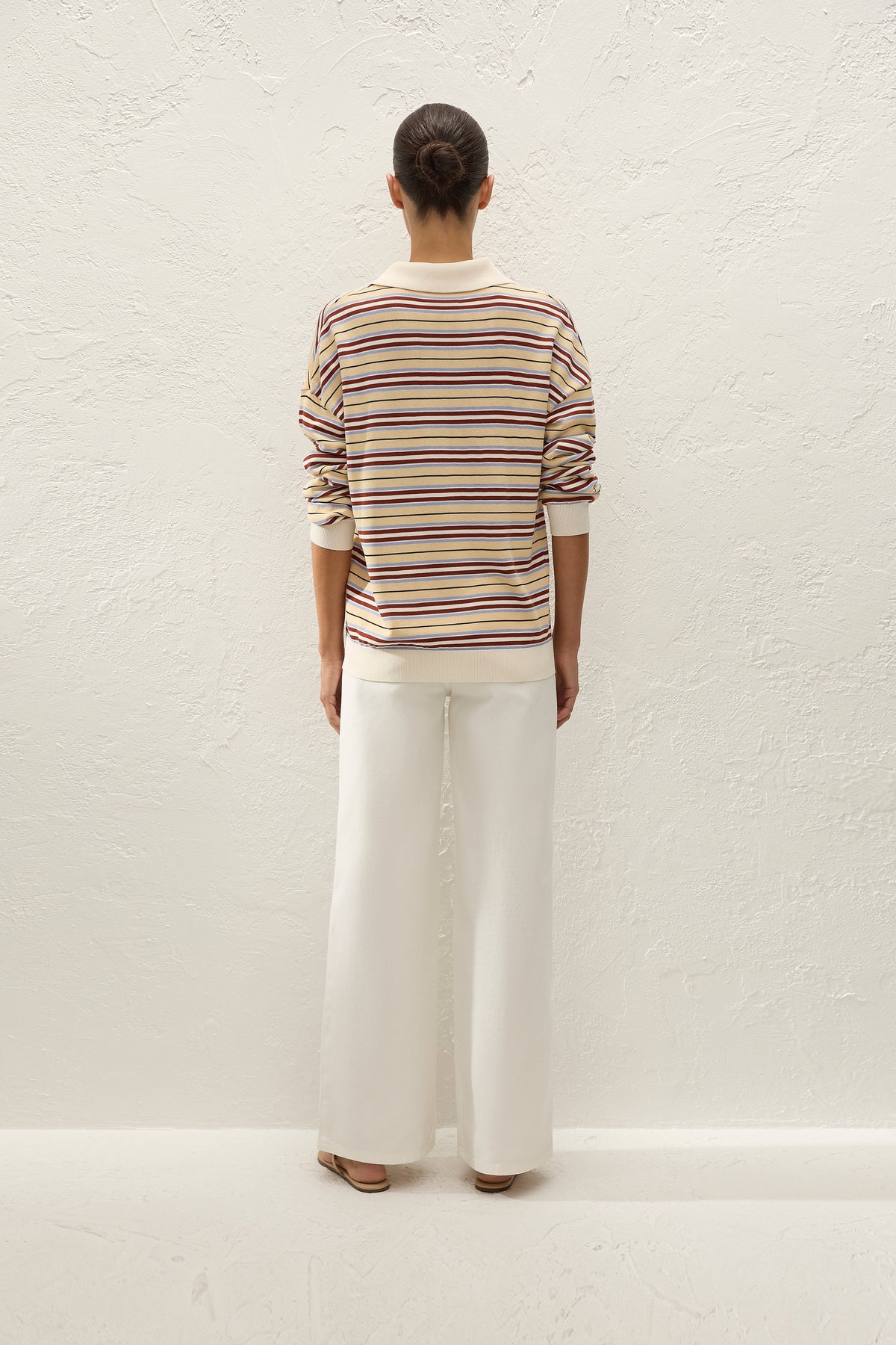 Back view showing the oversized striped silhouette, cream collar, ribbed hem and relaxed long sleeves.