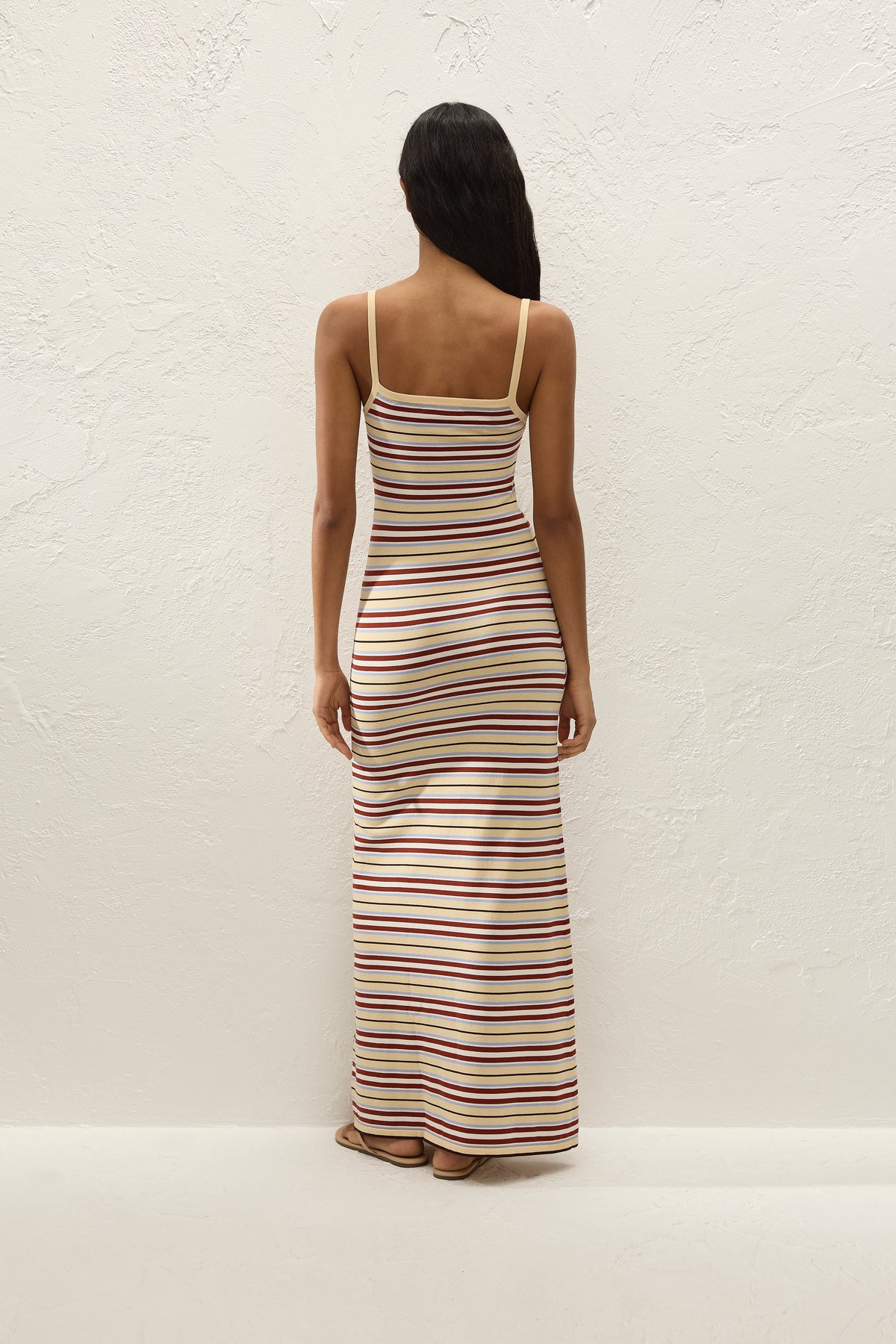 Back view showing the fitted shape, straight back neckline and long striped maxi skirt.