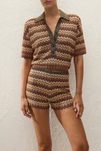 Close front view highlighting the zigzag stripe pattern, contrasting collar, button placket and subtle metallic finish.