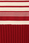 A close-up shows the red and cream striped knit pattern above the textured red skirt.
