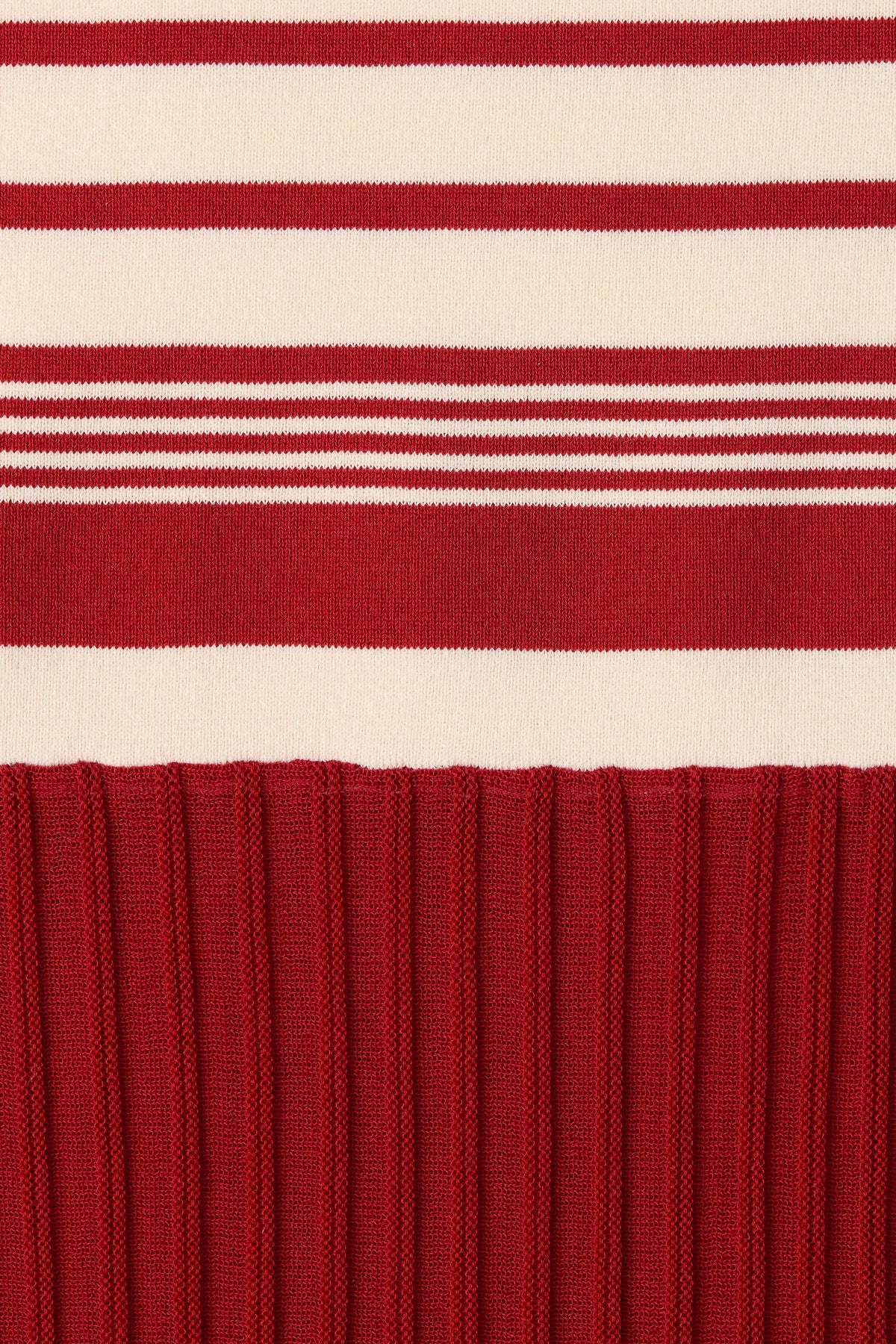 A close-up shows the red and cream striped knit pattern above the textured red skirt.
