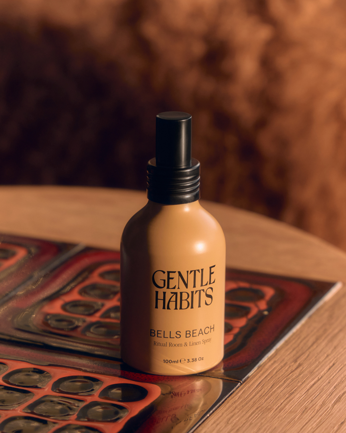 Gentle Habits Ritual Room & Linen Spray in Bells Beach shown in an amber-toned bottle with a black spray top.