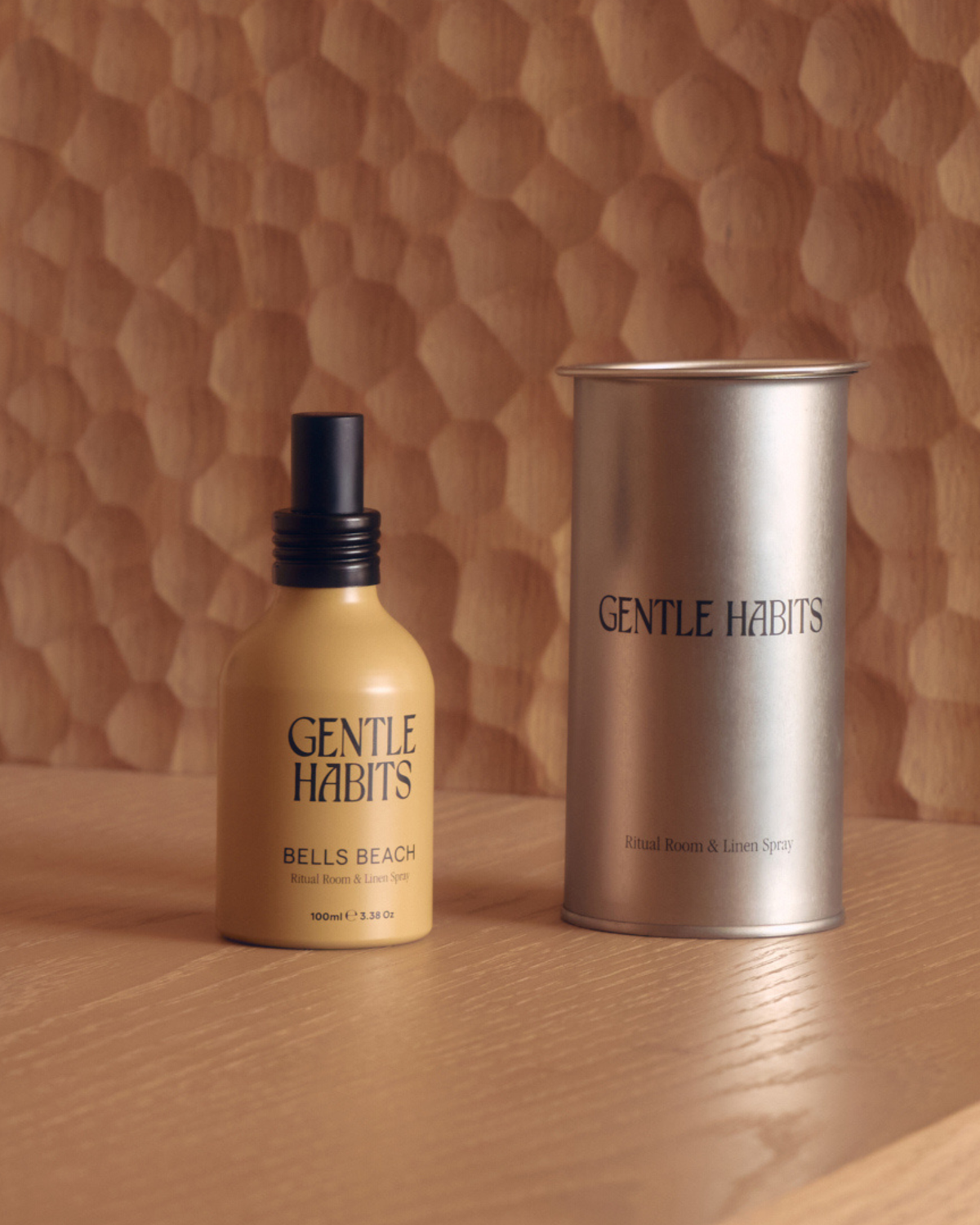 Bells Beach room and linen spray shown beside its cylindrical metal container on a wooden surface.