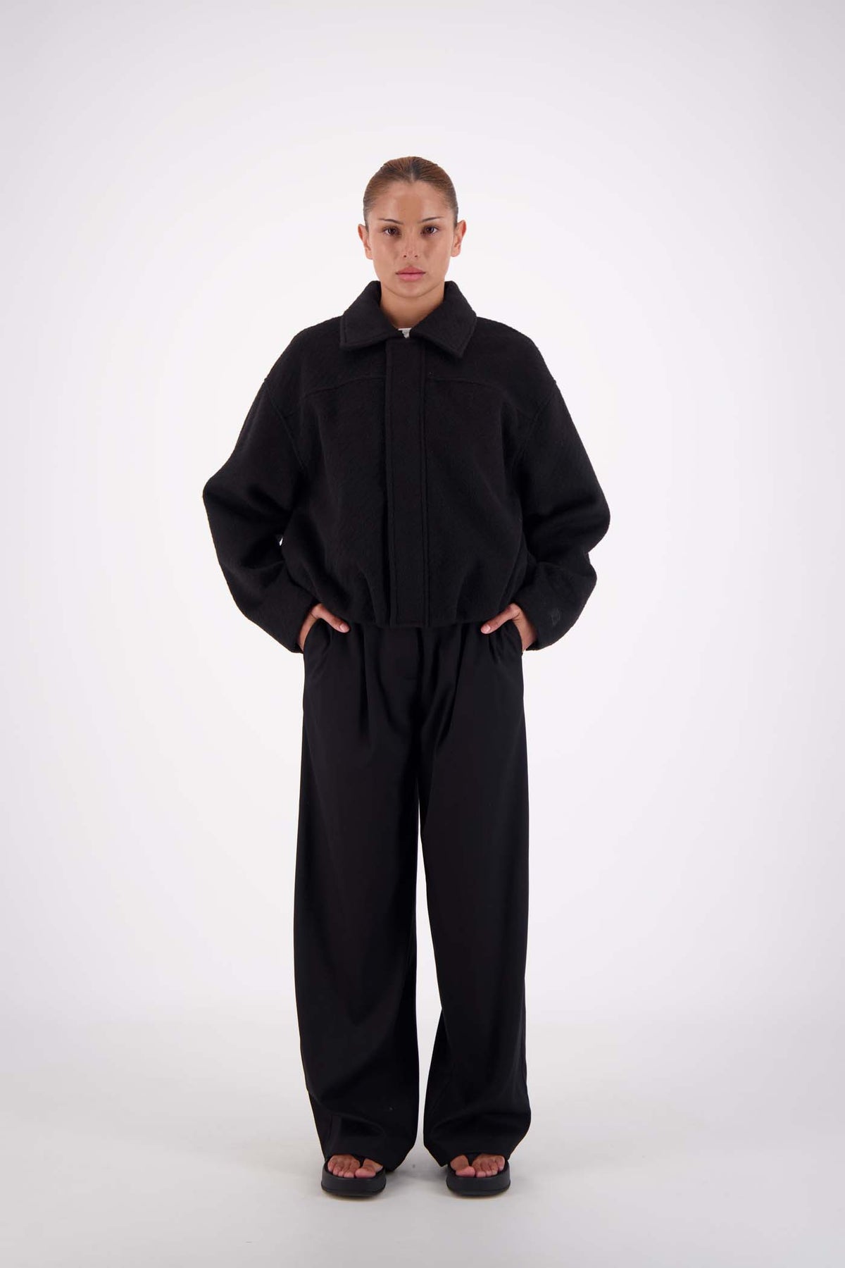 Jasmine Alexa Bailey Bomber Jacket in Black, full-length front view on model with collar folded down.

