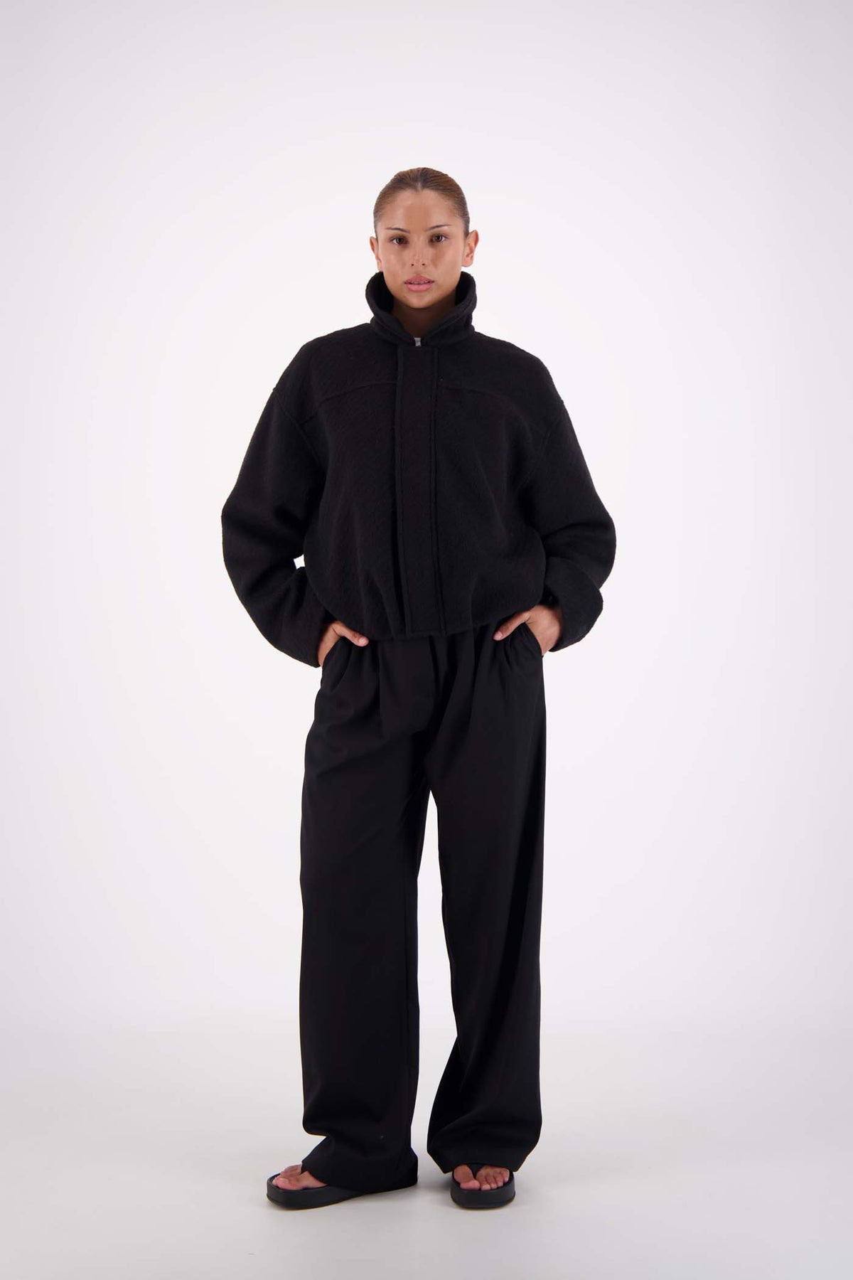 Jasmine Alexa Bailey Bomber Jacket in Black, angled front view on model with collar raised.
