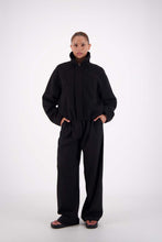 Jasmine Alexa Bailey Bomber Jacket in Black, angled front view on model with collar raised.
