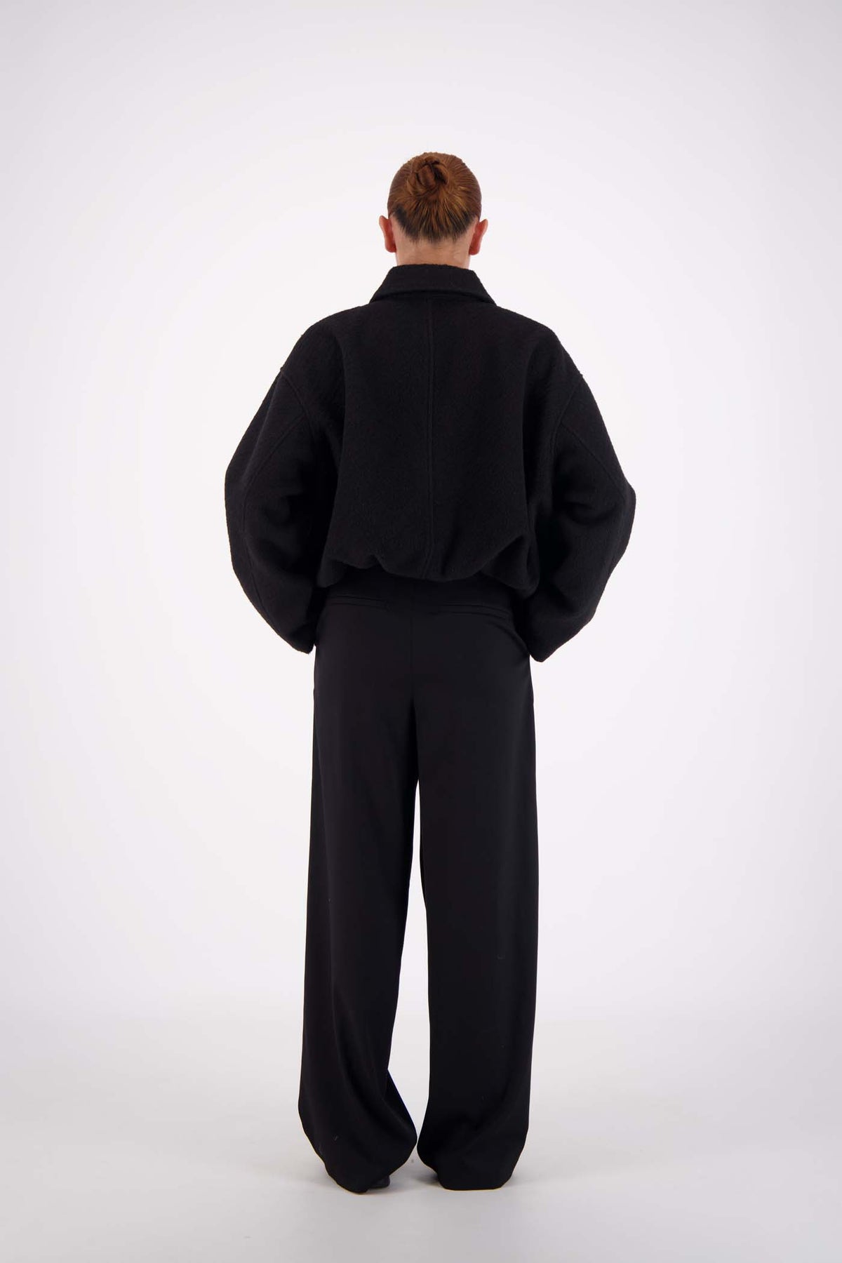 Jasmine Alexa Bailey Bomber Jacket in Black, full-length back view on model.
