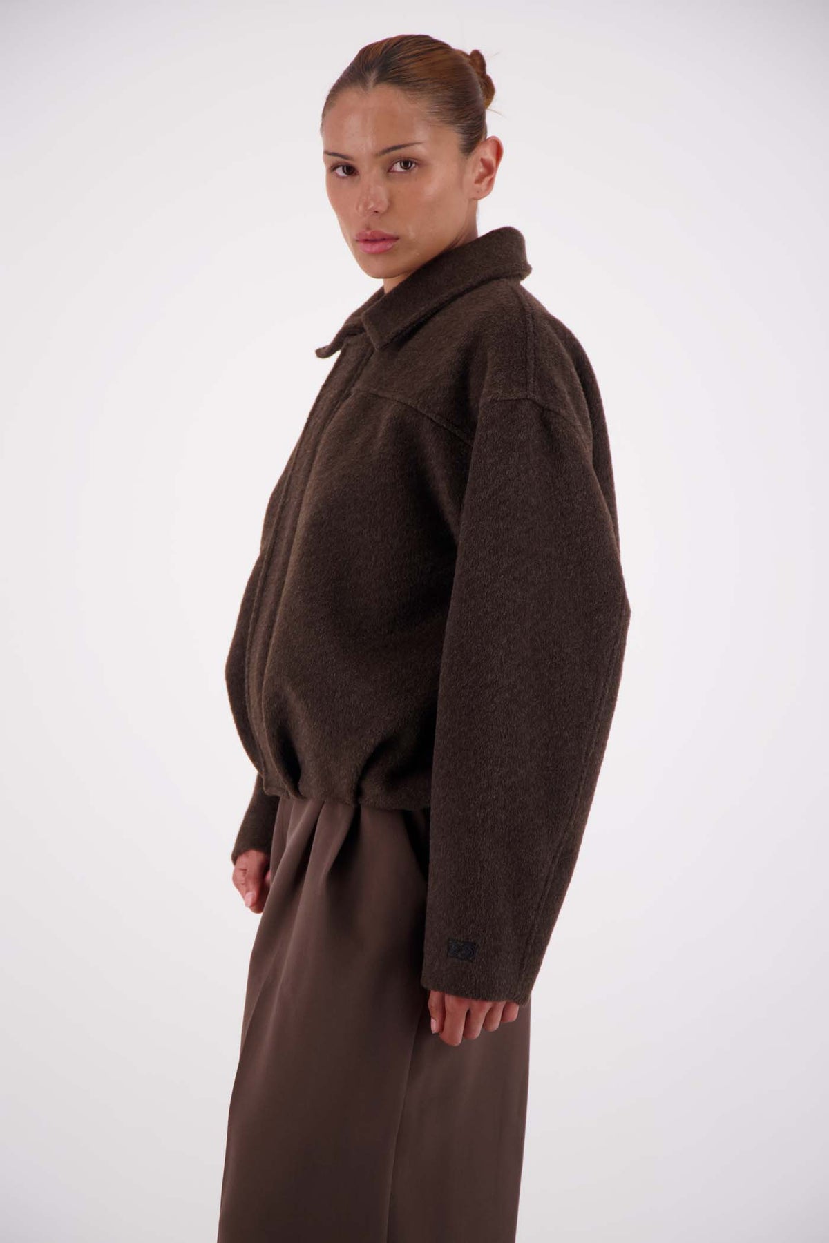 Jasmine Alexa Bailey Bomber Jacket in Brown, cropped side view showing the relaxed silhouette.
