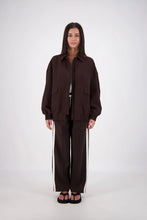 Person wearing a brown outfit on a white background
