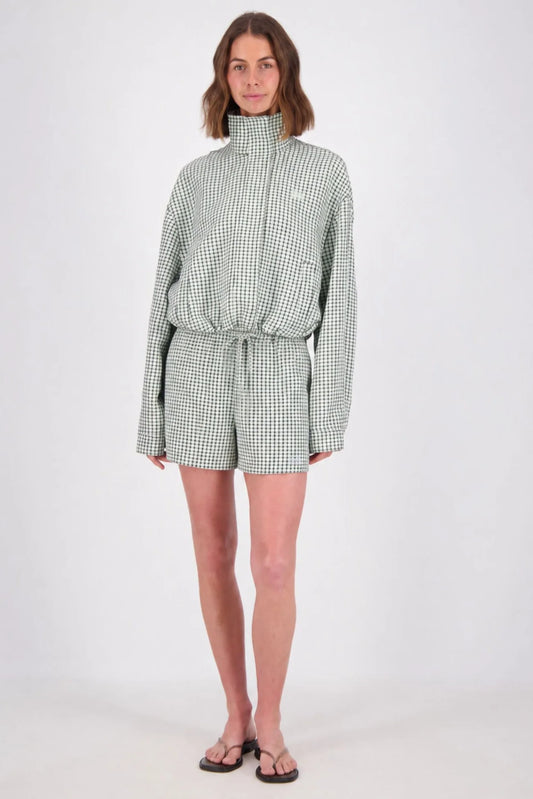 A full-length studio view of the white and mint check bomber jacket paired with matching shorts, showing the high neckline, drawstring hem and coordinated check pattern.