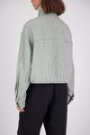 A rear studio view of the white and mint check bomber jacket, displaying the all-over grid pattern, back yoke seam, loose sleeves and cropped hem.
