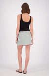 A rear view of a woman wearing a white and mint checked mini skort with a black sleeveless top, showing the back fit and hemline.