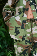 Camouflage jacket and pants worn by a person in a natural setting