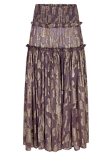 The purple metallic floral shirred maxi skirt is shown on its own with a wide shirred waistband, gathered tiers and a flowing full-length silhouette.