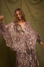 Model wearing the oversized purple shirt with metallic floral detailing, showing the wide sleeves, classic collar and flowing shape.