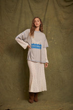 Model wearing the grey marl Inner Peace graphic tee layered over cream lace sleeves with a matching lace maxi skirt and brown boots in a full-length front view.