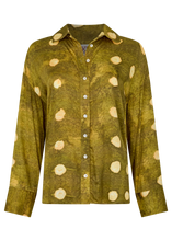Green shirt with beige polka dot pattern on a white background
