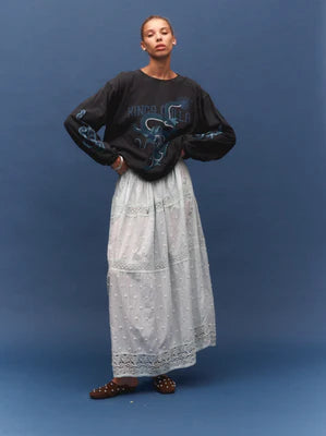 Model wearing a vintage black long-sleeve graphic tee with a light grey maxi skirt, showing the large blue dragon graphic, dropped shoulders and relaxed fit, front view