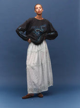 Model wearing a vintage black long-sleeve graphic tee with a light grey maxi skirt, showing the large blue dragon graphic, dropped shoulders and relaxed fit, front view