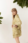Side view of the Dorato printed button-up shirt styled with matching ruffle shorts and silver bangles against a clean white backdrop with leafy branches.