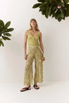 Full-length front view of the Dorato printed wide-leg pants styled with a light green tank top and black sandals against a clean white studio background.