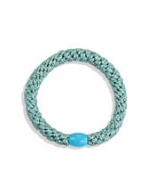 Green and silver glitter woven hair tie with a turquoise branded bead shown individually against a clean background.