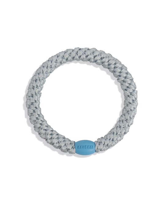 Baby Frost woven hair tie in a pale silver-blue shade with a light blue bead on a clean product background.