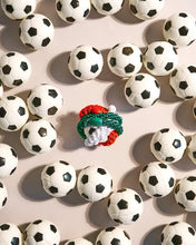 Forrest Green woven hair tie styled with colourful hair ties among miniature black and white soccer balls.