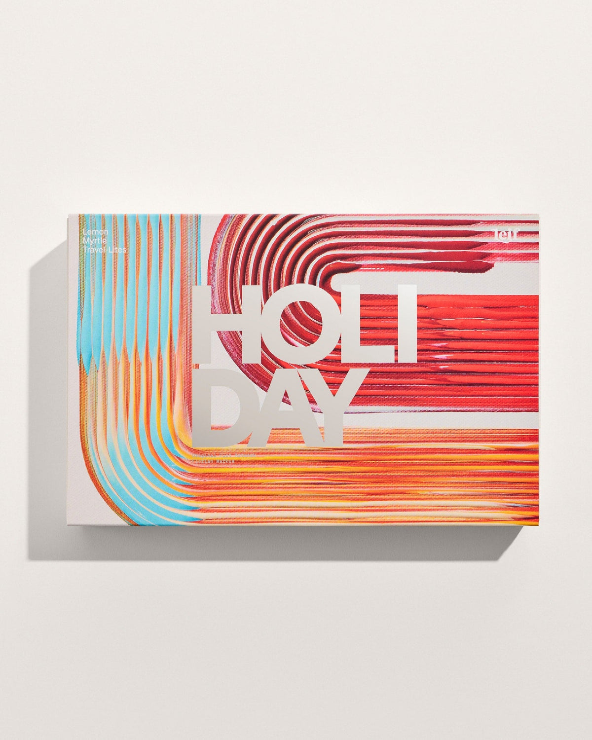 A rectangular gift box decorated with curved red, orange and turquoise artwork and large white lettering on a pale background.