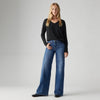 Model wearing the Levi's 318 Shaping Wide Leg Jeans in the Clever Girl wash with a black long-sleeve top, showing the high-rise fit and wide-leg silhouette in a full-length front view.