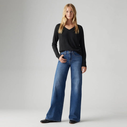 Model wearing the Levi's 318 Shaping Wide Leg Jeans in the Clever Girl wash with a black long-sleeve top, showing the high-rise fit and wide-leg silhouette in a full-length front view.