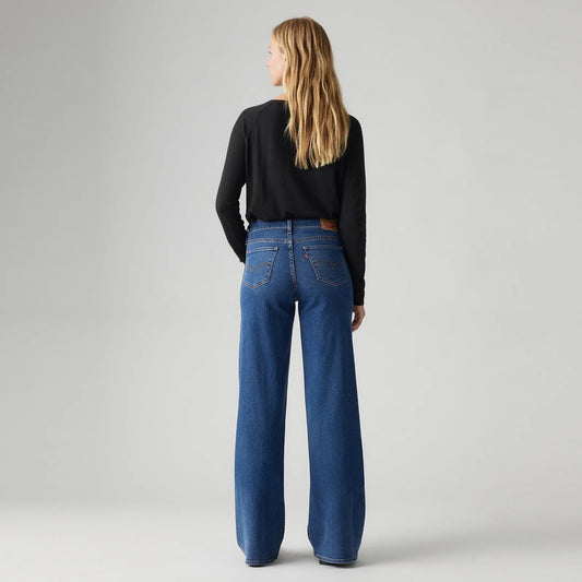 Model wearing the Levi's 318 Shaping Wide Leg Jeans in the Clever Girl wash, showing the back pockets, Levi's tab and wide-leg silhouette in a back view.