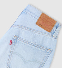 Light blue denim jeans with Levi's brand label on a gray background