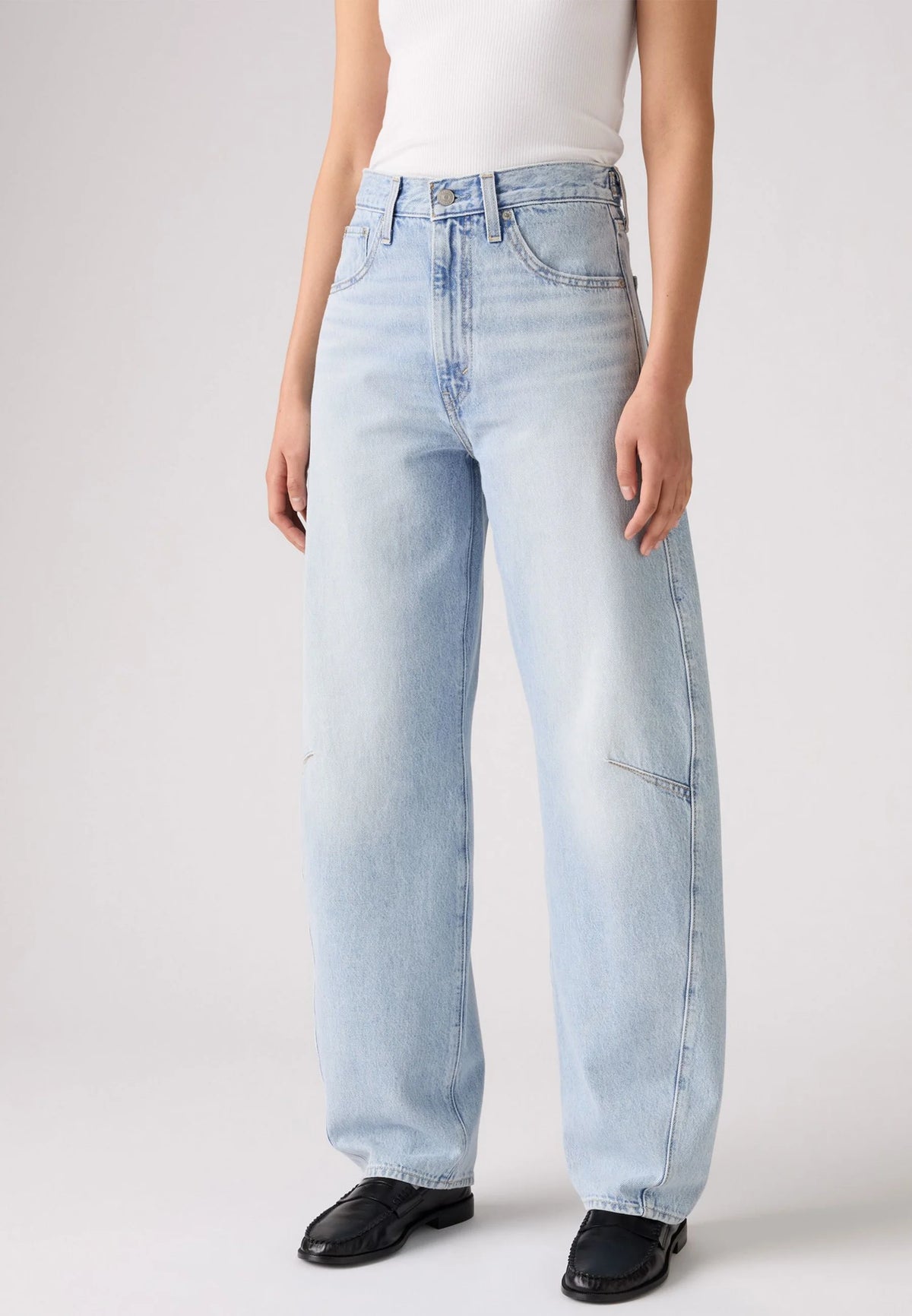 Close-up front view of the light-wash jeans showing the high-rise waistband, button closure, front pockets and curved leg seams.