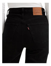 A close-up shows the back pockets, Levi’s tab and branded waistband patch on the black jeans.