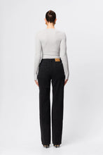 Person wearing black jeans and a white long-sleeve shirt on a white background