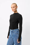 A model wears the Mossman Iris Top in black with blue jeans in an angled front studio view.
