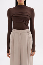 Close front view showing the raised neckline, draped bust panel and fitted silhouette.