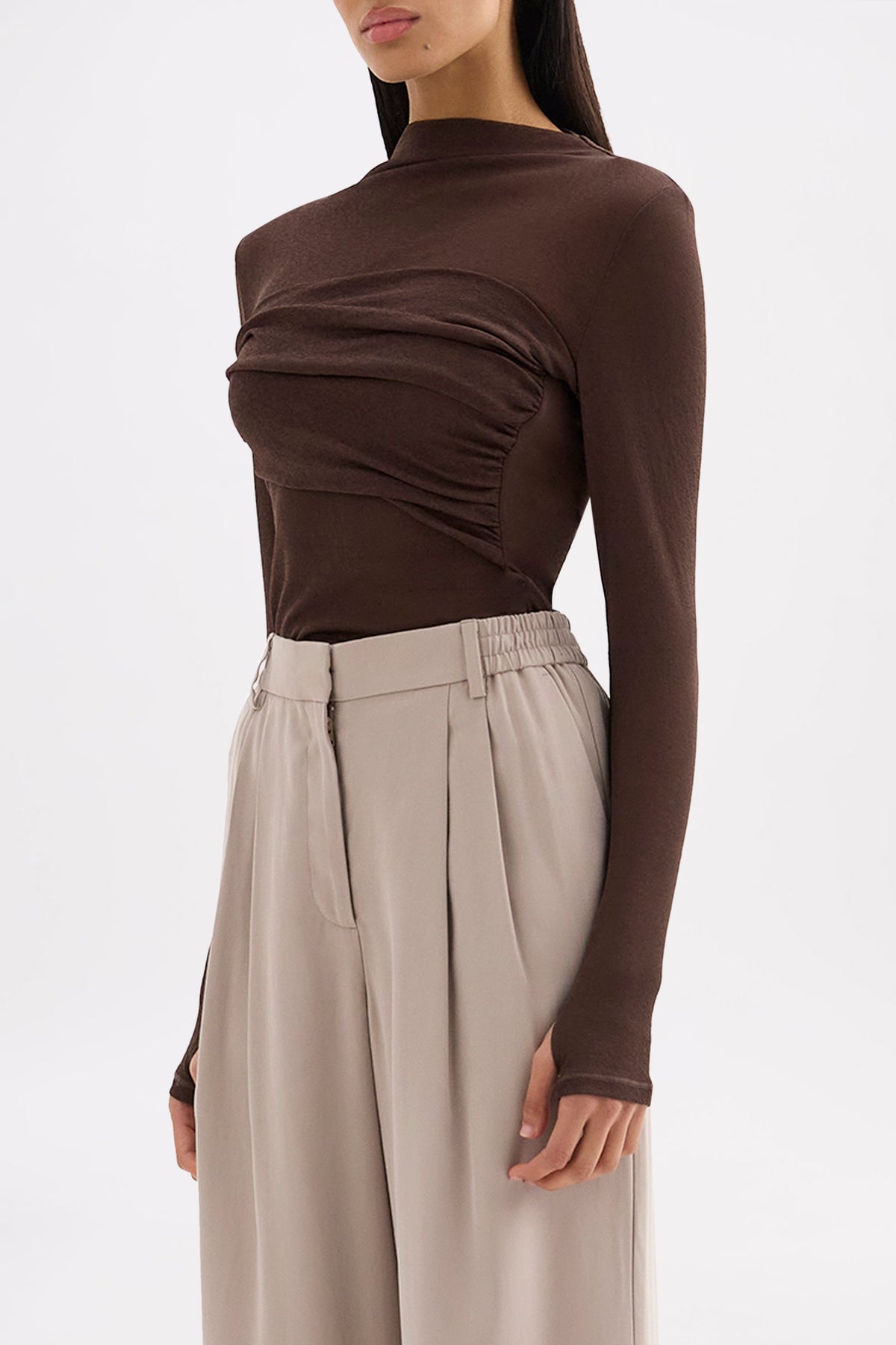 Three-quarter view highlighting the draped front detail, long sleeves and slim fit.