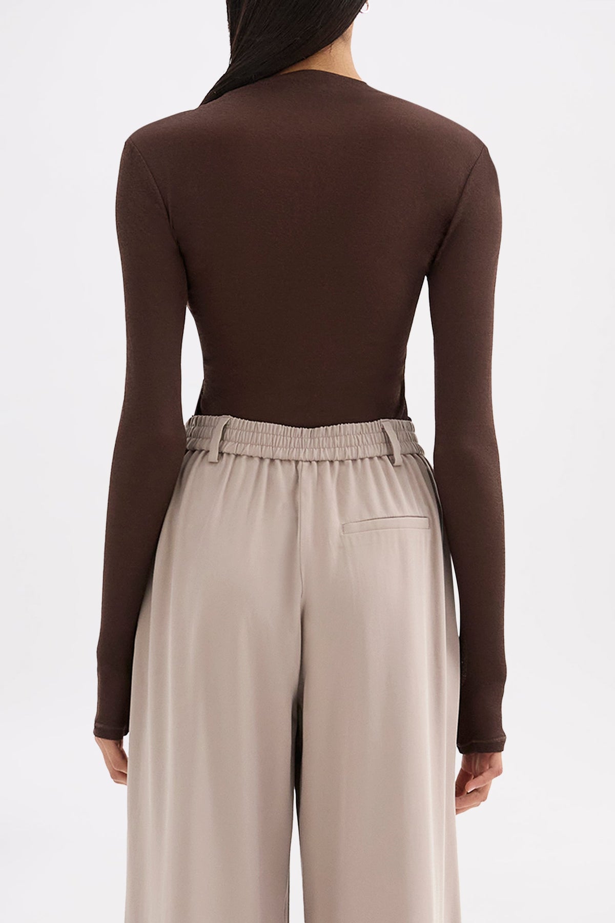 Back view showing the clean fitted shape, long sleeves and hip-length finish.