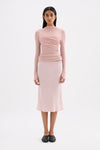 Pink fitted long sleeve top styled with a matching midi skirt in a full-length front view.