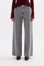 A front view shows the Steel wide-leg jeans with a low-rise waist and relaxed straight silhouette.
